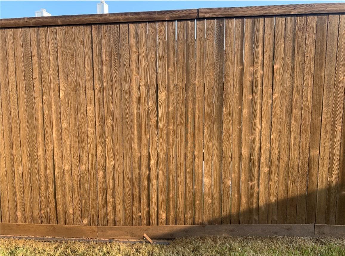 Fence with knotholes closeup-min stains cover the knots in the fence